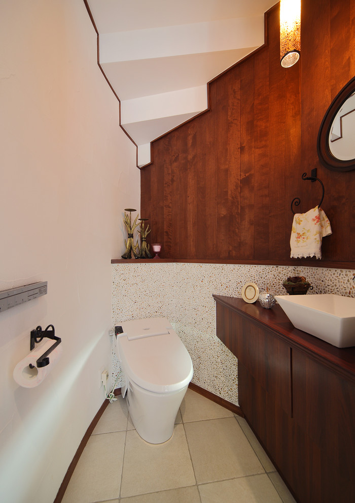 Источник вдохновения для домашнего уюта: туалет в стиле ретро с плоскими фасадами, темными деревянными фасадами, разноцветными стенами, настольной раковиной, столешницей из дерева, бежевым полом и коричневой столешницей