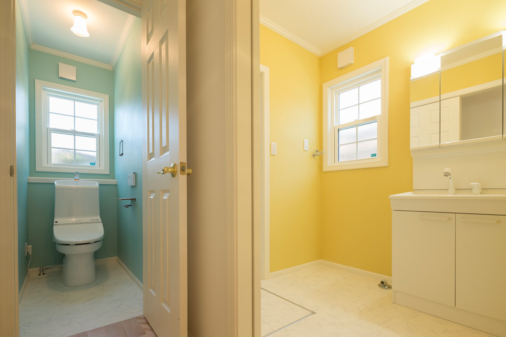 Photo of a traditional cloakroom in Other with flat-panel cabinets, white cabinets, multi-coloured walls and beige floors.