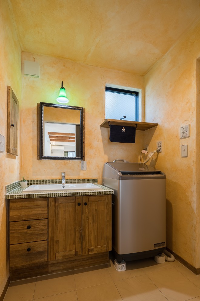Idee per un bagno di servizio etnico con pareti arancioni, pavimento in terracotta, lavabo da incasso e pavimento arancione