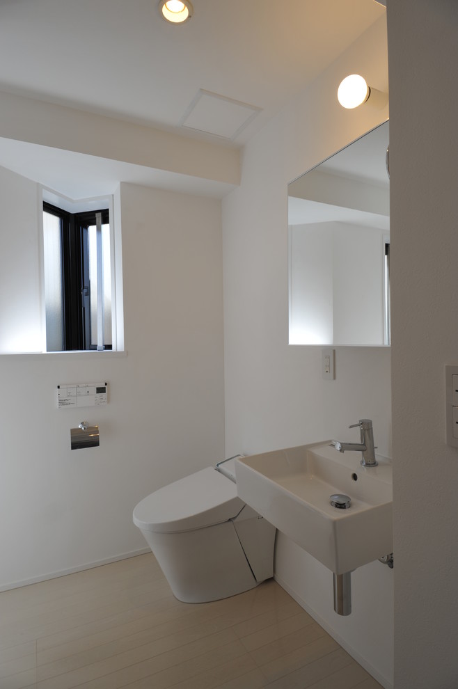 東京23区にある低価格の小さなコンテンポラリースタイルのおしゃれなトイレ・洗面所 (フラットパネル扉のキャビネット、白いキャビネット、白いタイル、白い壁、リノリウムの床、壁付け型シンク、タイルの洗面台、ベージュの床、白い洗面カウンター) の写真