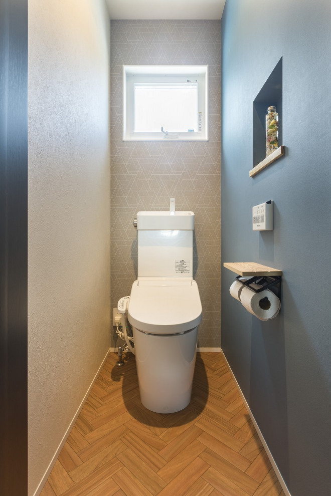 Стильный дизайн: туалет в стиле модернизм с унитазом-моноблоком, полом из винила и коричневым полом - последний тренд