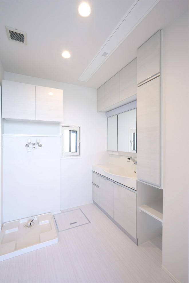 Idée de décoration pour un WC et toilettes minimaliste de taille moyenne avec un placard à porte plane, des portes de placard blanches, un sol beige, un plan de toilette blanc, meuble-lavabo encastré, un plafond en papier peint et du papier peint.
