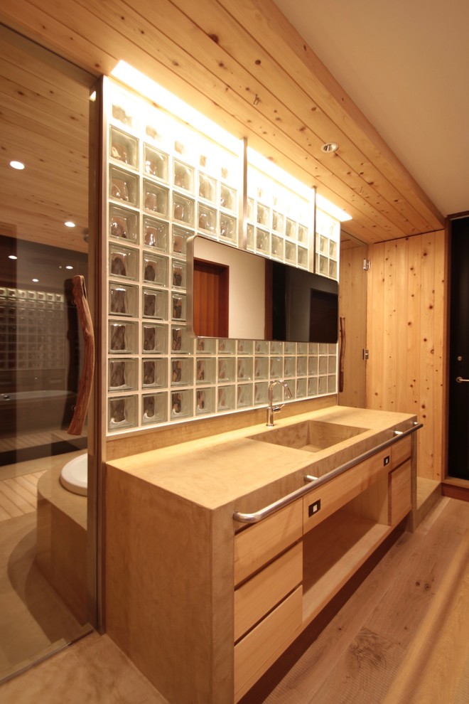 東京23区にあるコンテンポラリースタイルのおしゃれなトイレ・洗面所 (フラットパネル扉のキャビネット、茶色いキャビネット、茶色い壁、無垢フローリング、一体型シンク、茶色い床、ブラウンの洗面カウンター) の写真