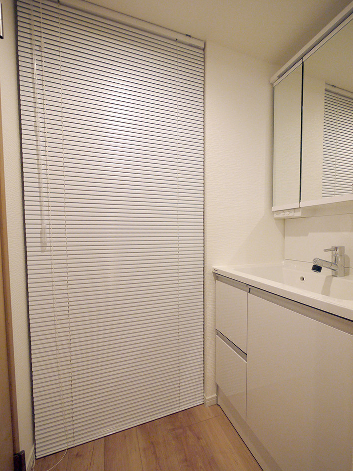 東京23区にある北欧スタイルのおしゃれなトイレ・洗面所 (白いキャビネット、白い壁、無垢フローリング、ベージュの床、白い洗面カウンター) の写真