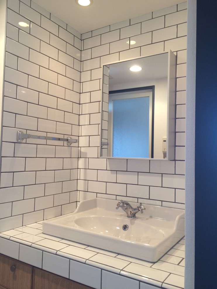 Immagine di un bagno di servizio stile americano con piastrelle bianche, piastrelle diamantate e pareti bianche