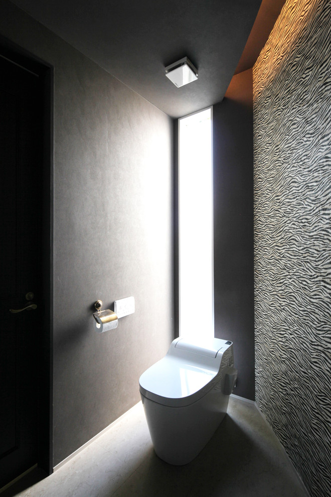 Diseño de aseo contemporáneo con paredes negras y suelo gris