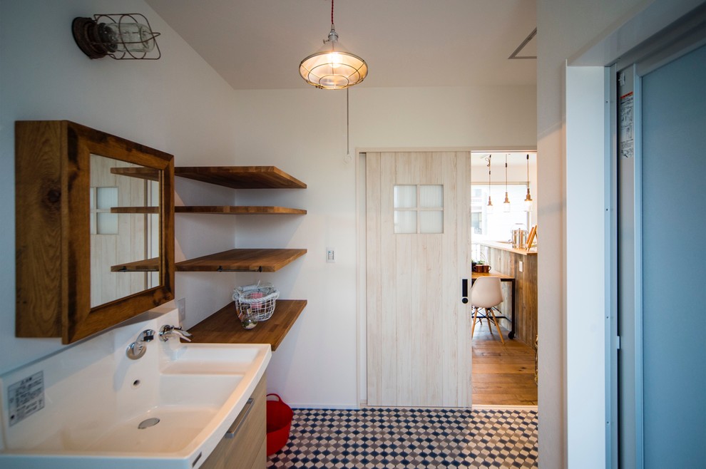 Foto på ett stort maritimt toalett, med öppna hyllor, bruna skåp, skifferkakel, vita väggar, vinylgolv, ett integrerad handfat, träbänkskiva och blått golv