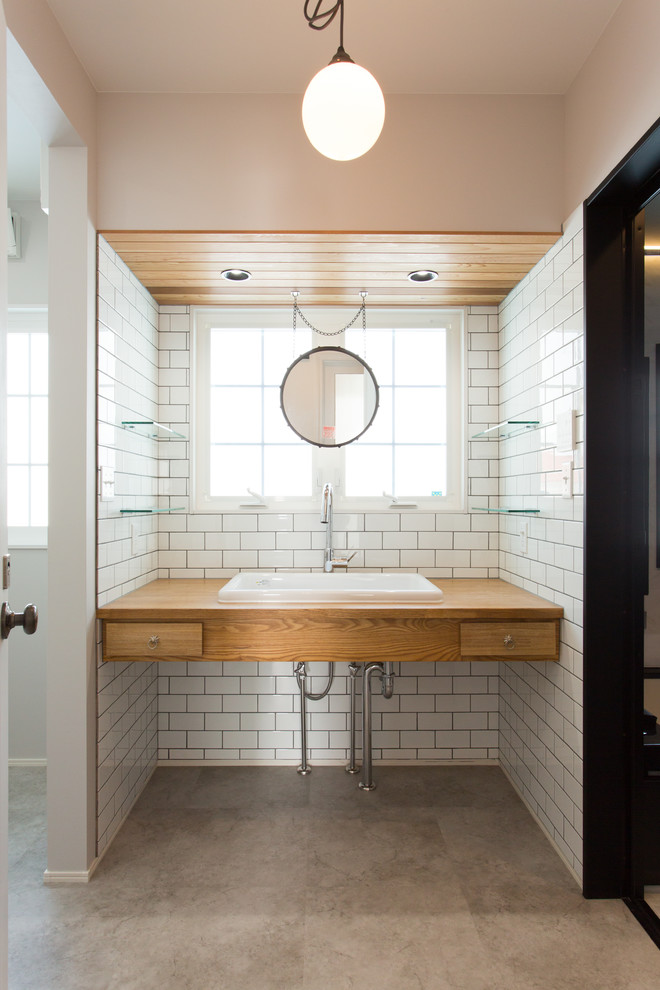 Inspiration pour un WC et toilettes design en bois brun de taille moyenne avec un placard à porte plane, un mur blanc, sol en béton ciré, un lavabo posé et un sol gris.