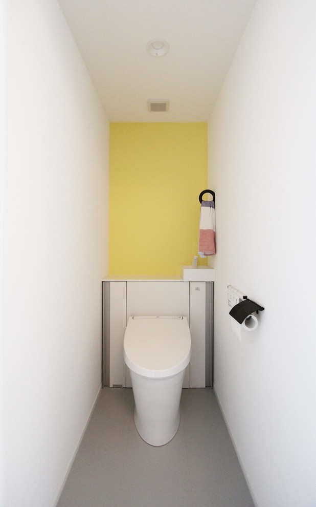 東京23区にあるインダストリアルスタイルのおしゃれなトイレ・洗面所 (マルチカラーの壁、グレーの床) の写真