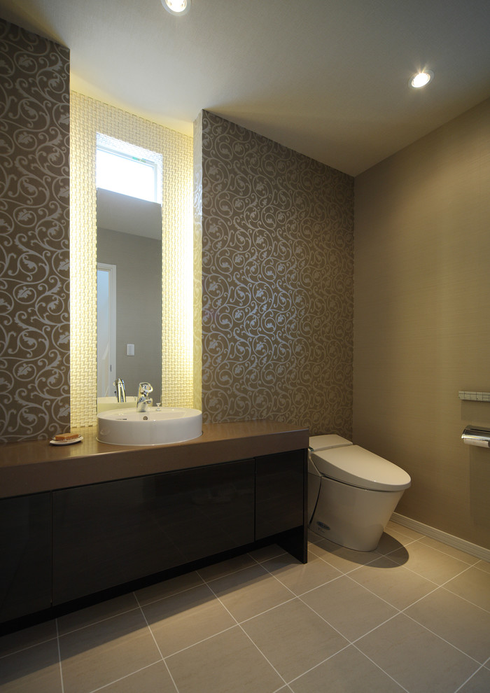 Inspiration for a modern cloakroom in Tokyo with a one-piece toilet, beige walls, a vessel sink and beige floors.