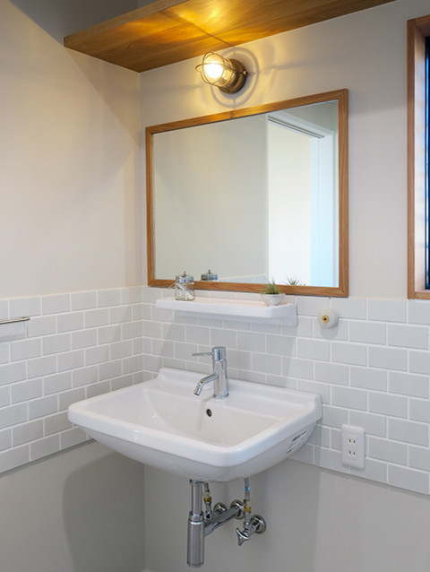 Inspiration for a small scandi cloakroom in Other with medium wood cabinets, white tiles, metro tiles, white walls, porcelain flooring, a wall-mounted sink and grey floors.