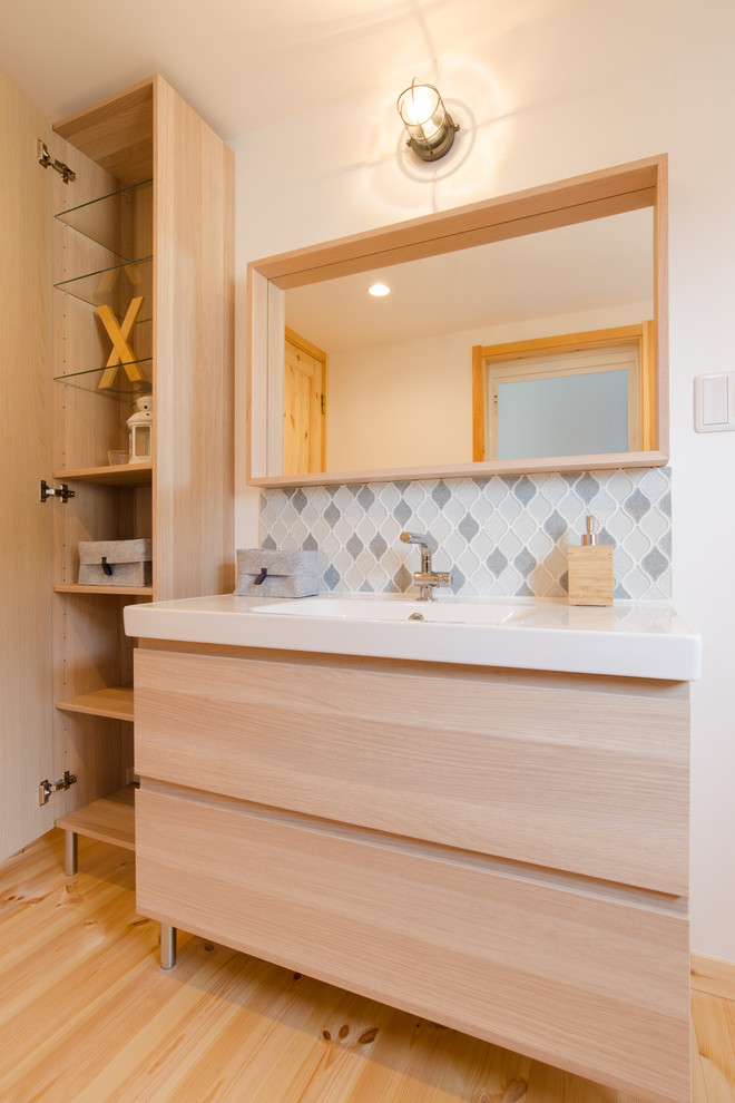 Inspiration for a medium sized scandinavian cloakroom in Other with flat-panel cabinets, light wood cabinets, multi-coloured tiles, glass tiles, white walls, light hardwood flooring, an integrated sink, solid surface worktops, beige floors and white worktops.