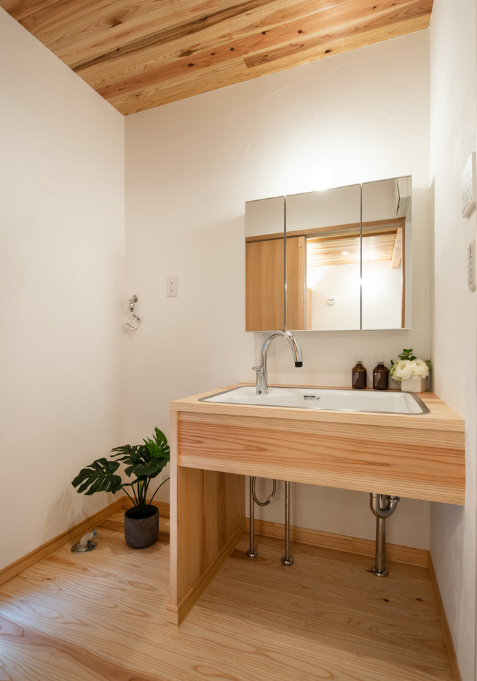 東京23区にあるカントリー風のおしゃれなトイレ・洗面所 (白い壁、淡色無垢フローリング、アンダーカウンター洗面器、ベージュの床) の写真