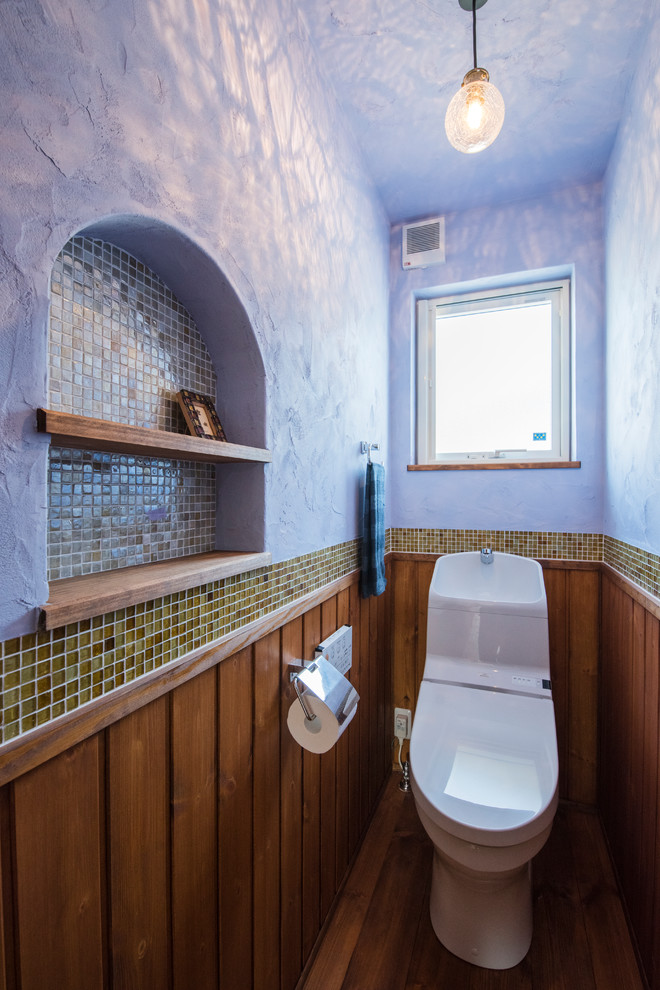 Пример оригинального дизайна: туалет в стиле фьюжн с темным паркетным полом, зеленой плиткой, плиткой мозаикой, синими стенами и коричневым полом