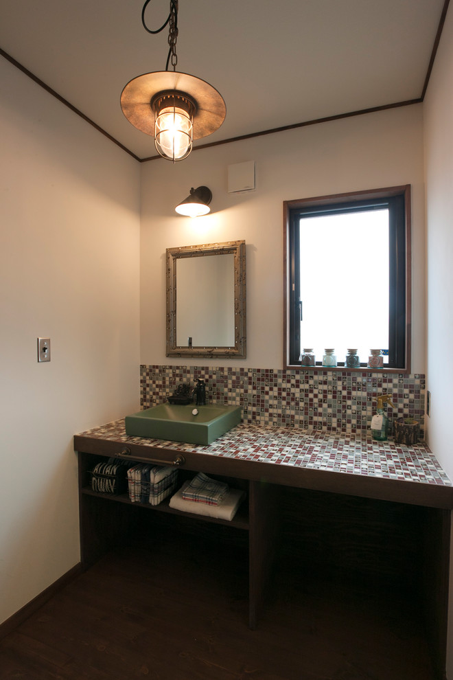 Inspiration för ett orientaliskt flerfärgad flerfärgat toalett, med öppna hyllor, skåp i slitet trä, vita väggar, ett fristående handfat, kaklad bänkskiva och brunt golv