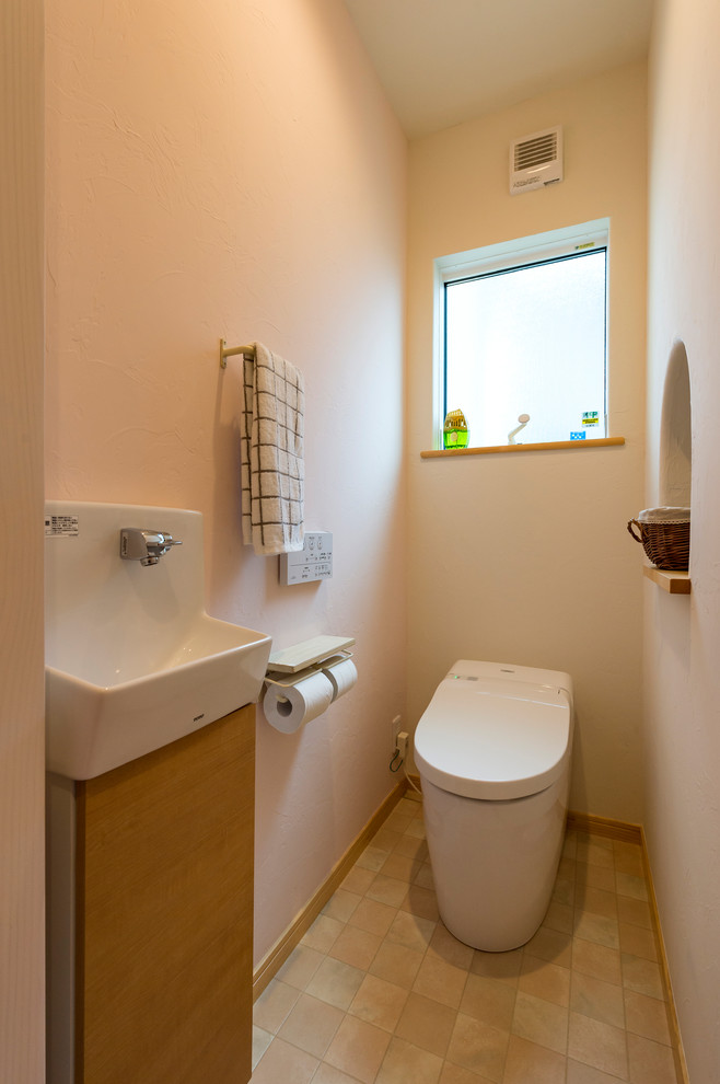 Esempio di un bagno di servizio mediterraneo con ante lisce, ante in legno scuro, pareti bianche, lavabo a colonna e pavimento beige