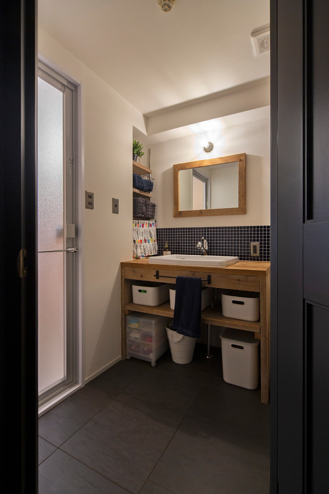 Immagine di un piccolo bagno di servizio moderno con nessun'anta, piastrelle blu, piastrelle in ceramica, pareti grigie, top in legno e pavimento grigio