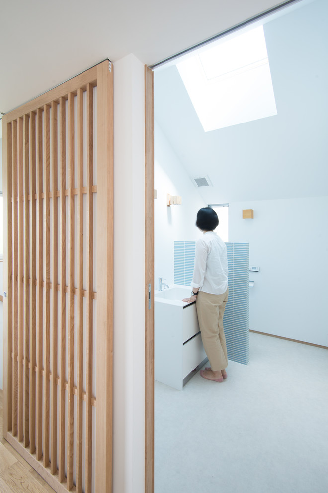 Идея дизайна: туалет в скандинавском стиле с унитазом-моноблоком, синей плиткой и керамической плиткой