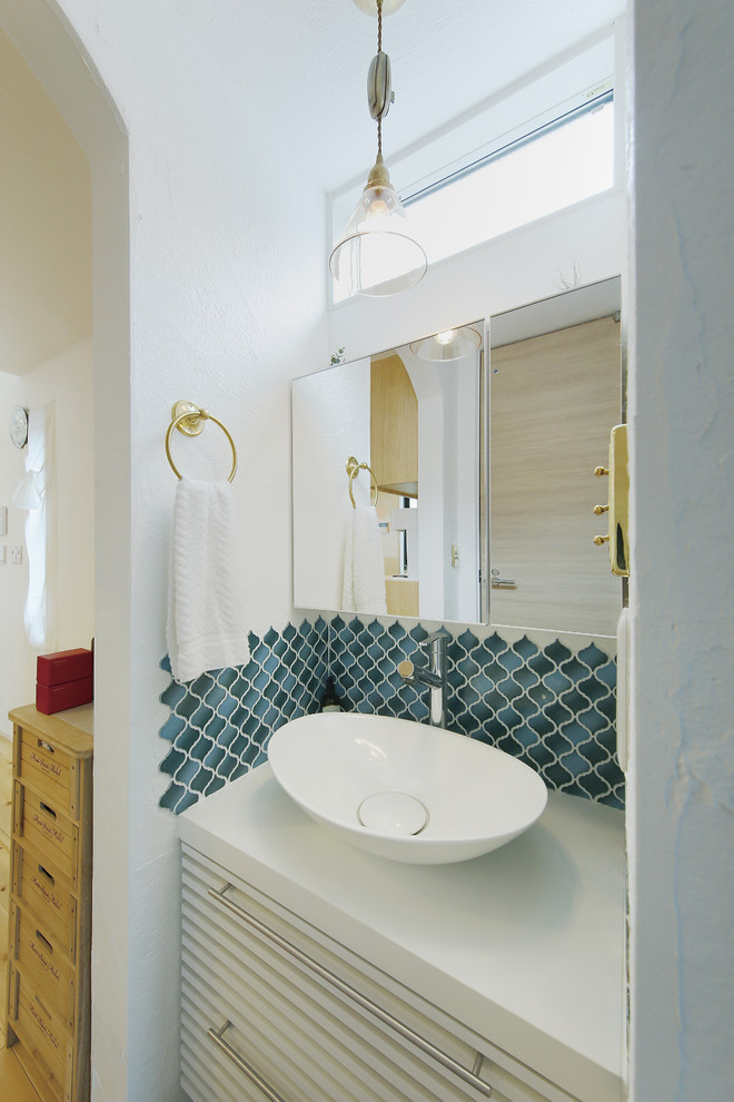 東京23区にある低価格の北欧スタイルのおしゃれなトイレ・洗面所 (家具調キャビネット、白いキャビネット、青いタイル、磁器タイル、白い壁、濃色無垢フローリング、ベッセル式洗面器) の写真