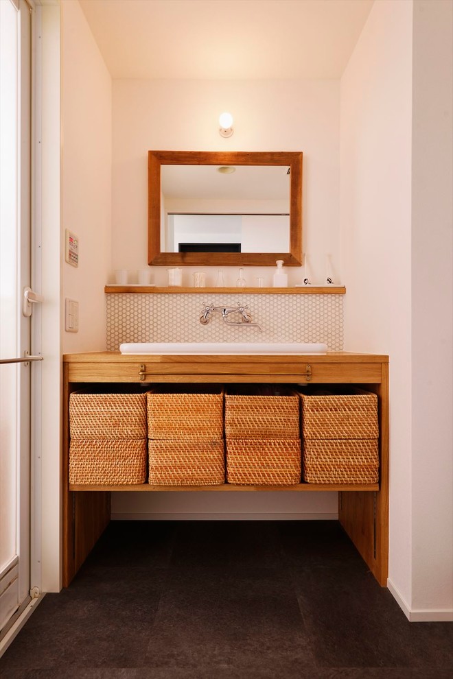 Diseño de aseo escandinavo con armarios abiertos, paredes blancas, encimera de madera, suelo gris y encimeras marrones