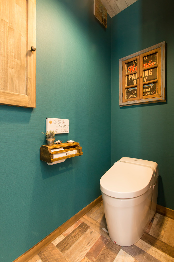 Réalisation d'un WC et toilettes champêtre avec un mur vert et un sol marron.