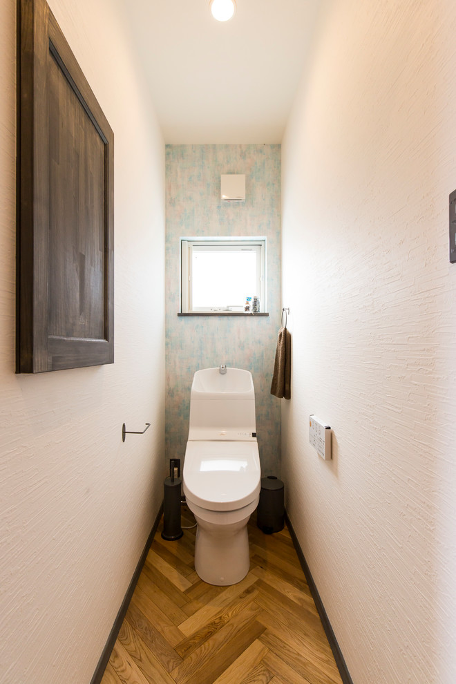 Immagine di un bagno di servizio mediterraneo con pareti multicolore, pavimento in legno massello medio e pavimento marrone