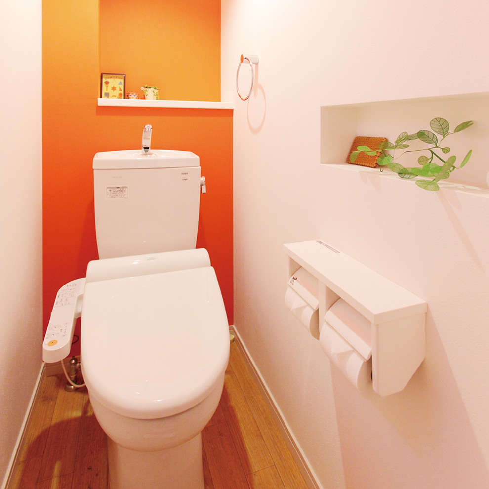 Immagine di un bagno di servizio nordico di medie dimensioni con nessun'anta, ante bianche, WC monopezzo, pareti arancioni e pavimento marrone