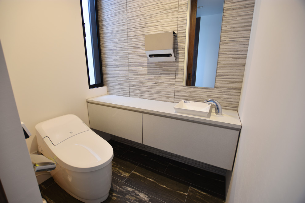 Idee per un bagno di servizio minimalista con ante bianche, piastrelle grigie, piastrelle in gres porcellanato, pavimento in vinile e pavimento nero