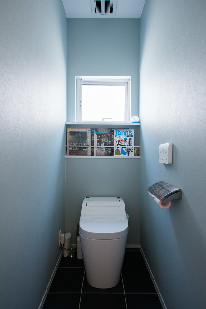 他の地域にあるコンテンポラリースタイルのおしゃれなトイレ・洗面所 (磁器タイルの床、黒い床) の写真