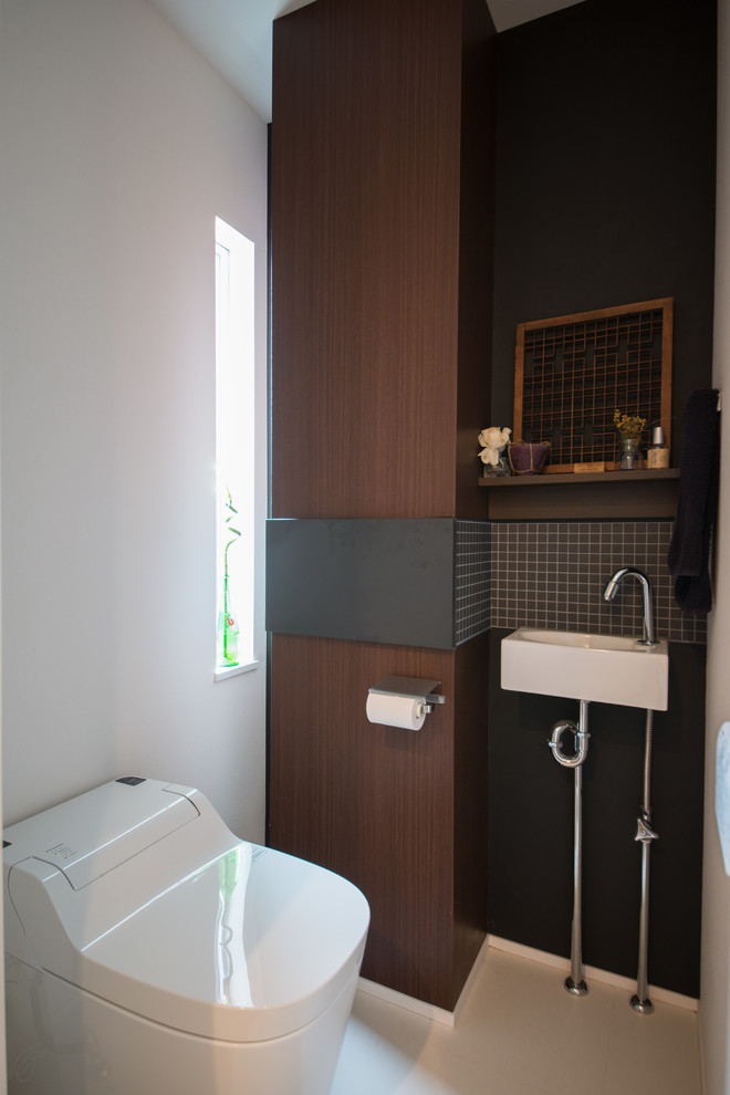 他の地域にあるモダンスタイルのおしゃれなトイレ・洗面所 (濃色木目調キャビネット、白いタイル、磁器タイル、白い壁) の写真