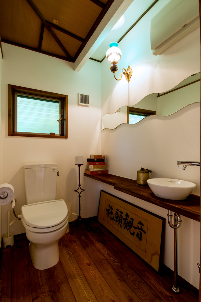 Ispirazione per un bagno di servizio etnico con pareti bianche, parquet scuro, lavabo a bacinella, top in legno, pavimento marrone e top marrone