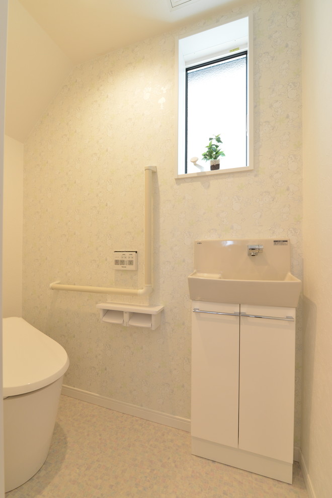 他の地域にあるモダンスタイルのおしゃれなトイレ・洗面所 (フラットパネル扉のキャビネット、白いキャビネット、一体型トイレ	、白い壁、ベージュの床) の写真