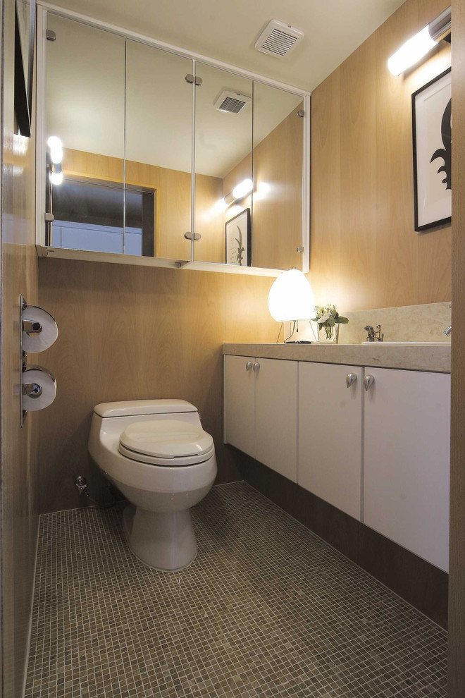Immagine di un bagno di servizio minimalista con ante bianche e pareti beige
