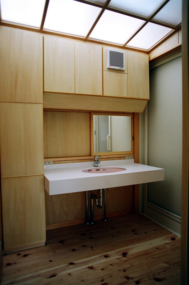 Idee per un piccolo bagno di servizio con consolle stile comò, pareti bianche, parquet chiaro, lavabo sottopiano, top in superficie solida e top bianco