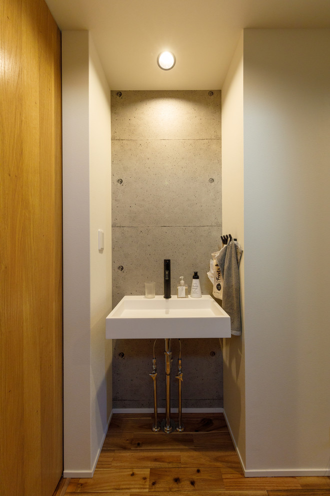 Exempel på ett industriellt toalett, med grå väggar, mellanmörkt trägolv och brunt golv