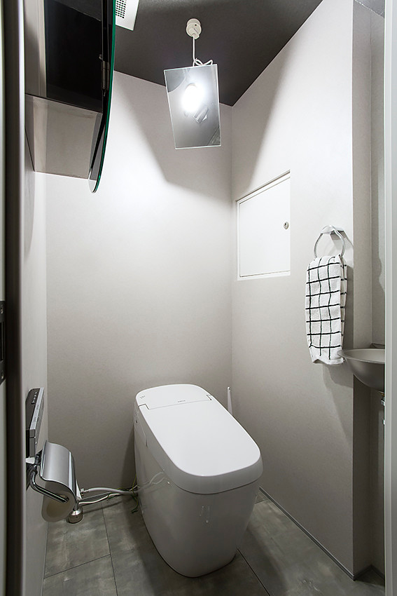 Aménagement d'un petit WC et toilettes contemporain avec un placard sans porte, des portes de placard noires, WC séparés, un mur gris, un sol en vinyl, un plan de toilette en acier inoxydable, un sol gris et un plan de toilette gris.