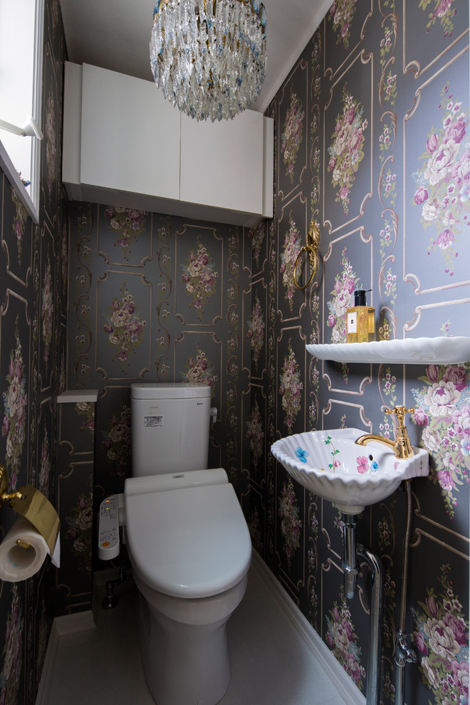 Cette image montre un WC et toilettes minimaliste avec un mur gris, un plan vasque et un sol gris.