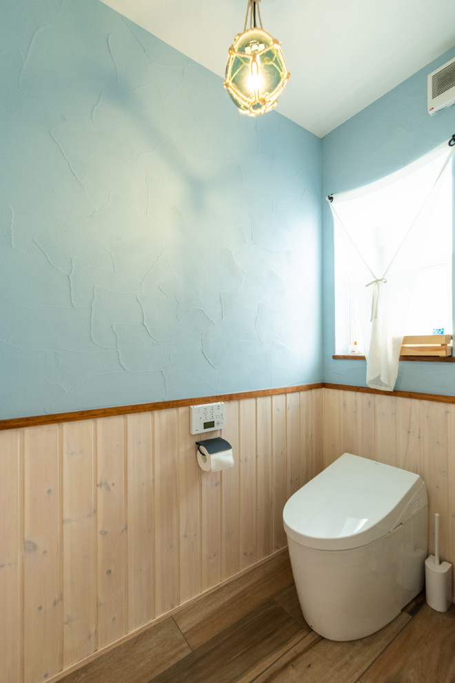 他の地域にあるカントリー風のおしゃれなトイレ・洗面所 (青い壁、淡色無垢フローリング、ベージュの床) の写真