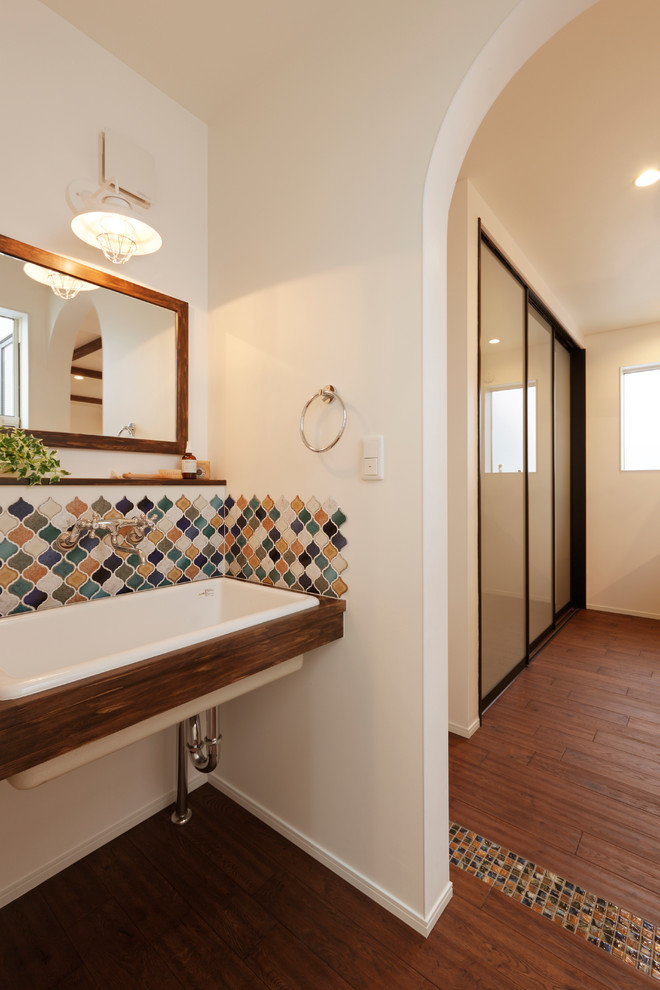 Esempio di un bagno di servizio design con piastrelle multicolore, pareti bianche, pavimento in legno massello medio, top in legno e pavimento marrone