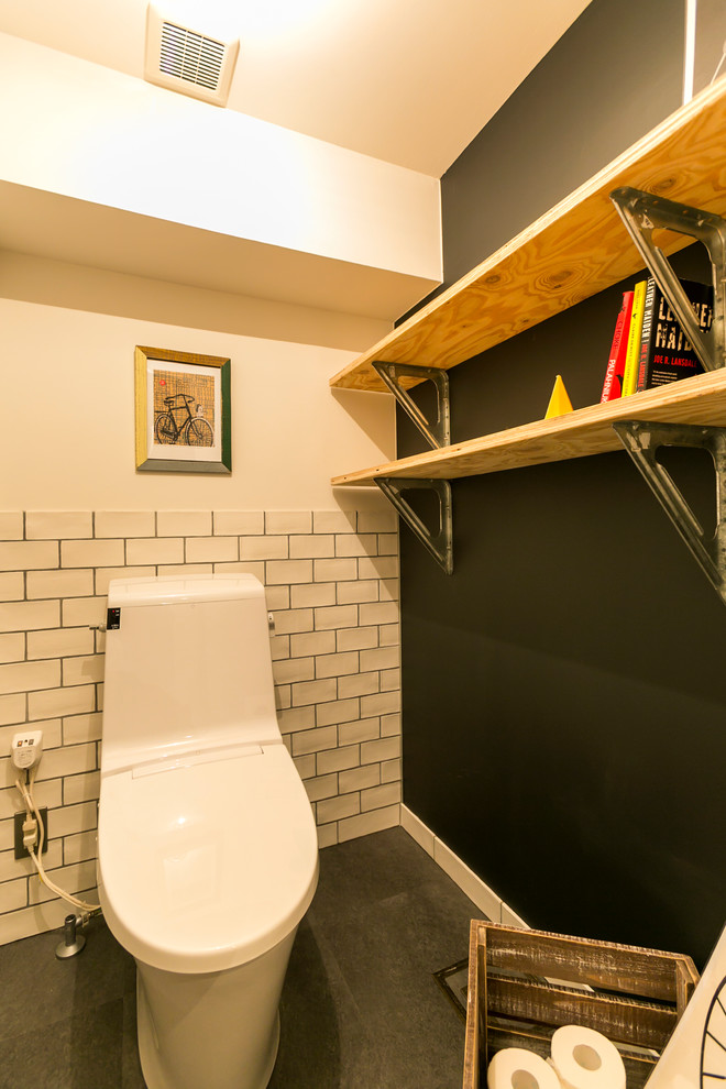 Cette photo montre un WC et toilettes industriel avec un mur multicolore et un sol gris.