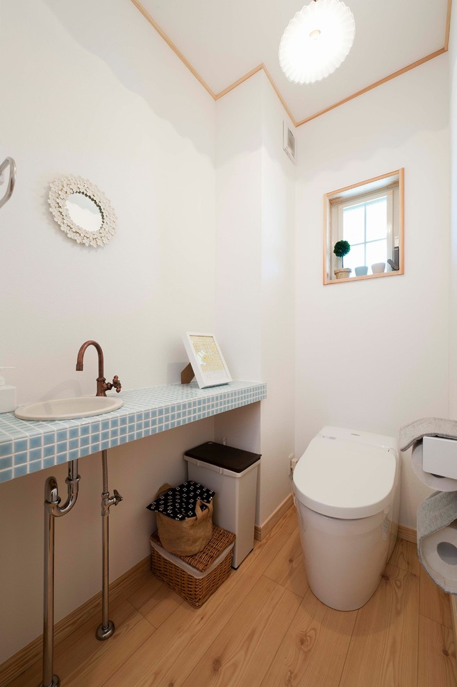 他の地域にあるアジアンスタイルのおしゃれなトイレ・洗面所 (白い壁、無垢フローリング、茶色い床) の写真