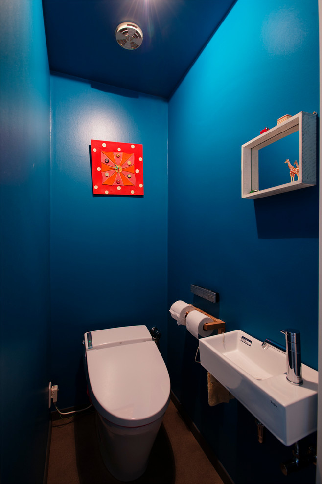 東京都下にあるコンテンポラリースタイルのおしゃれなトイレ・洗面所 (一体型トイレ	、青い壁、壁付け型シンク) の写真