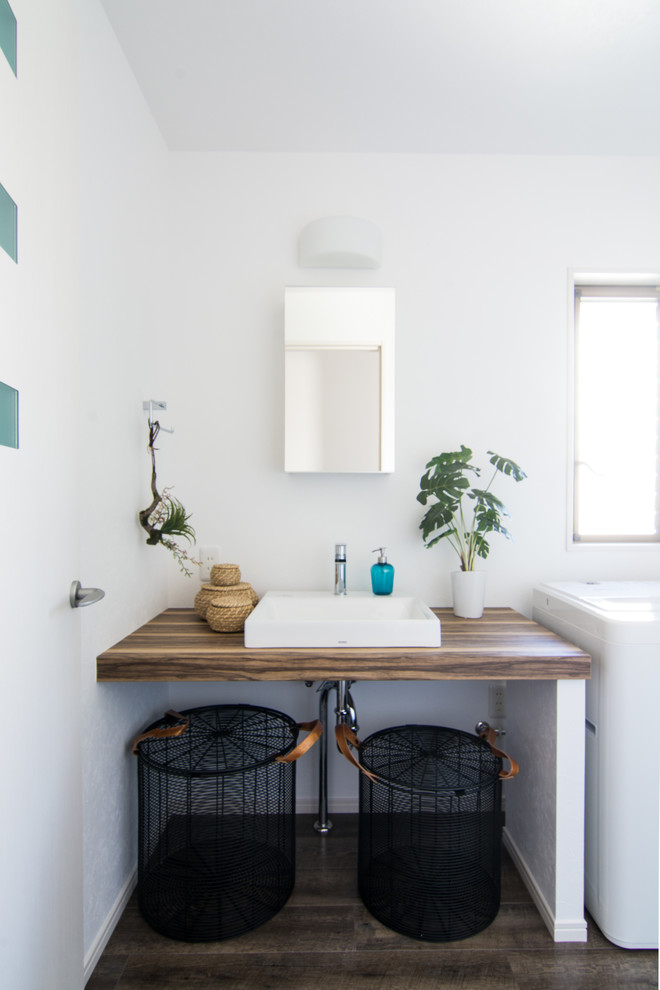 Inspiration för skandinaviska brunt toaletter, med vita väggar, mörkt trägolv, ett fristående handfat, träbänkskiva och brunt golv