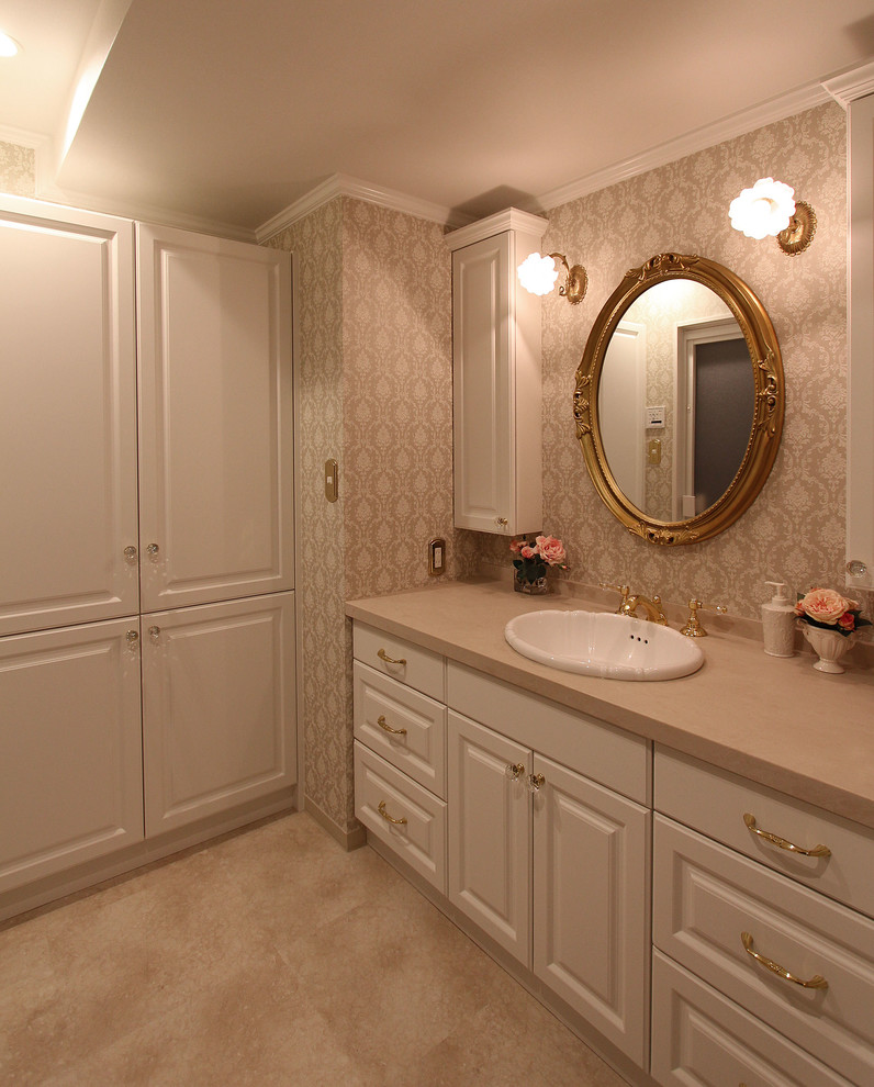 Idée de décoration pour un WC et toilettes victorien avec un mur beige, un lavabo posé et un sol beige.