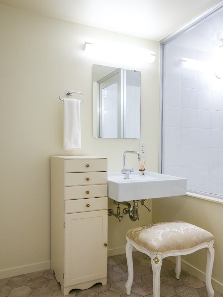 Aménagement d'un WC et toilettes classique de taille moyenne avec un mur blanc, un sol en vinyl, un lavabo suspendu et un sol gris.