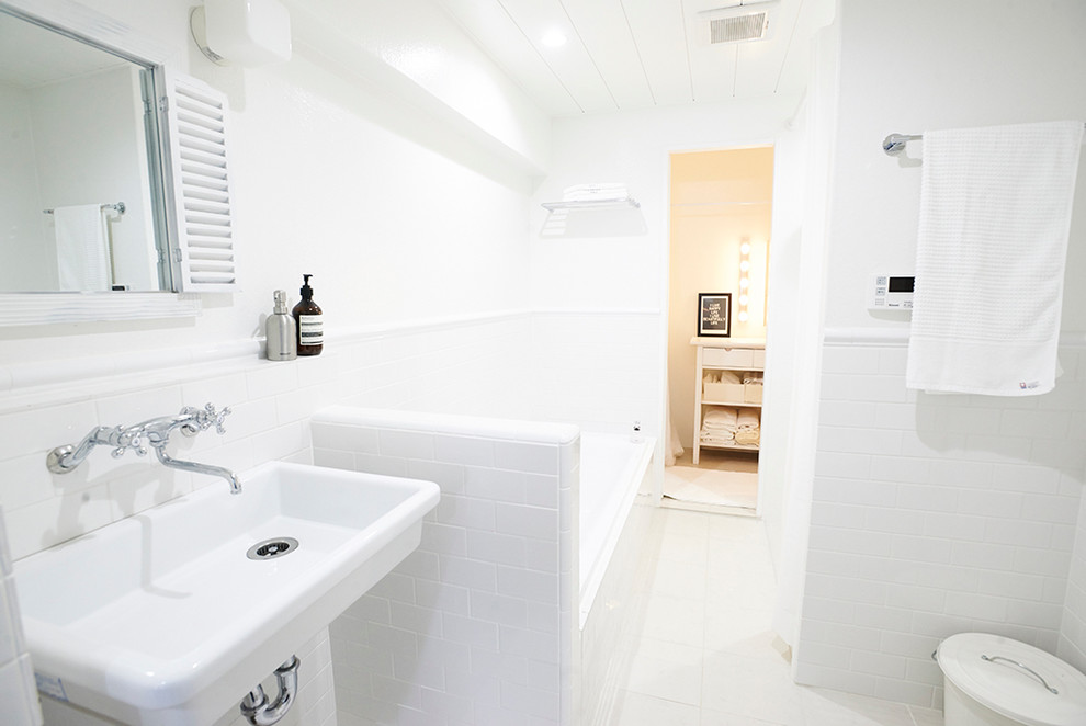 Idéer för att renovera ett mellanstort funkis vit vitt toalett, med vit kakel, marmorkakel, vita väggar, klinkergolv i porslin, kaklad bänkskiva och vitt golv