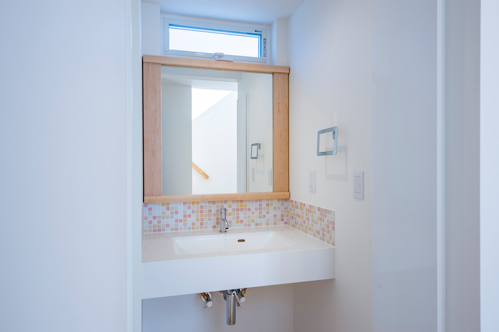 Inspiration för ett funkis toalett, med vita skåp, flerfärgad kakel, mosaik, vita väggar, ljust trägolv, ett integrerad handfat, bänkskiva i akrylsten och öppna hyllor