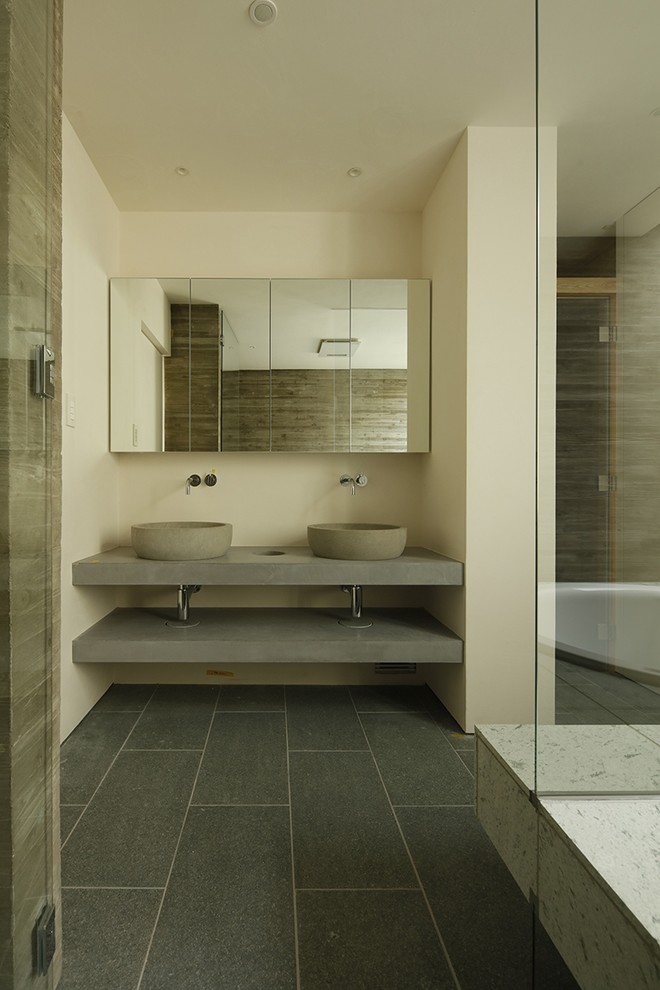 Cette photo montre un WC et toilettes moderne avec un placard sans porte, des portes de placard grises, un mur blanc, une vasque, un plan de toilette en béton, un sol gris et un plan de toilette gris.