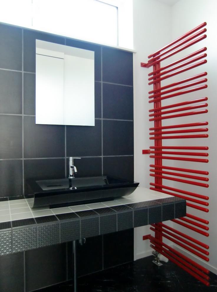 Design ideas for a modern cloakroom in Other with a vessel sink, tiled worktops, black floors, black tiles, porcelain tiles, white walls, plywood flooring and black worktops.