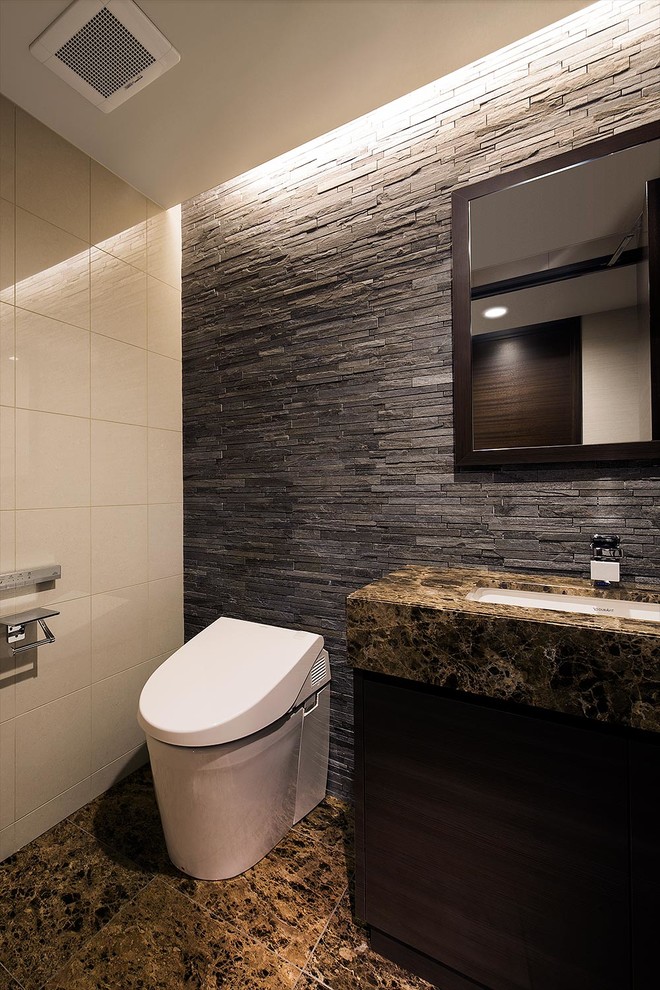 Réalisation d'un WC et toilettes minimaliste avec des portes de placard marrons, WC à poser, un carrelage noir et blanc, un mur multicolore, un sol en marbre, un lavabo encastré, un plan de toilette en marbre, un sol marron et un plan de toilette marron.
